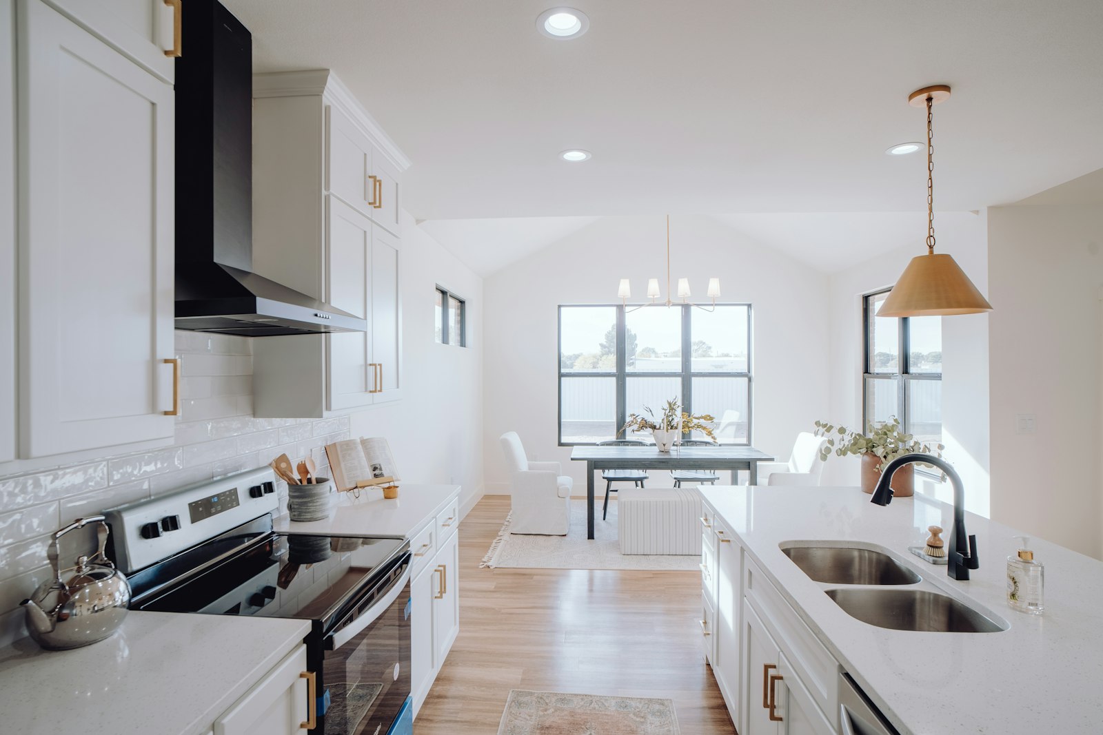 Bright kitchen with a sink under a window and a clean countertop ready for use.